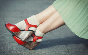 Legs of woman with high heels dressed green dress vintage style outdoor